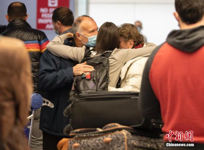 当地时间11月8日，一位女士在美国加州旧金山国际机场的国际航班到达区域拥抱来自法国的父母。美国8日起放宽入境限制，允许完成新冠疫苗全程接种的外国旅客乘坐国际航班或通过水陆口岸入境。 中新社记者 刘关关 摄