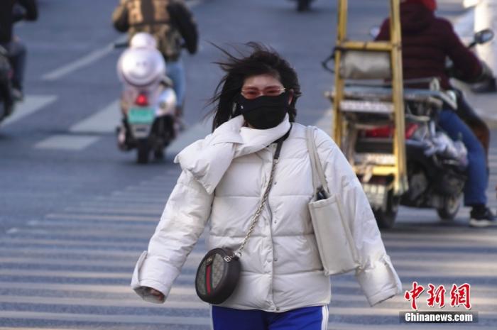 资料图：市民在大风中行走。 中新社记者 韩章云 摄 　