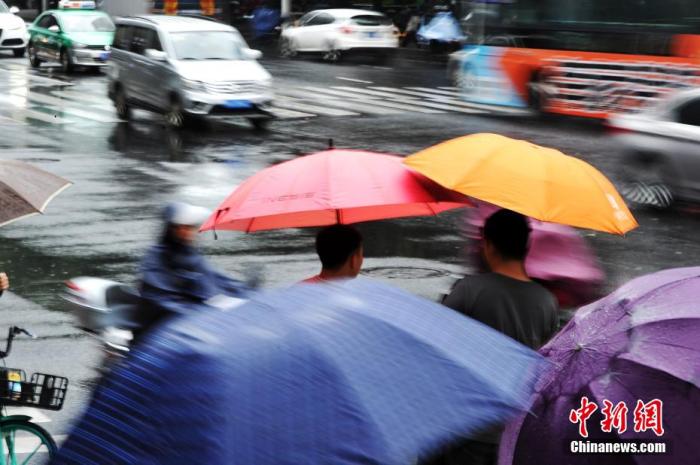 资料图为11月22日，福建福州，市民在雨中出行。 张斌 摄
