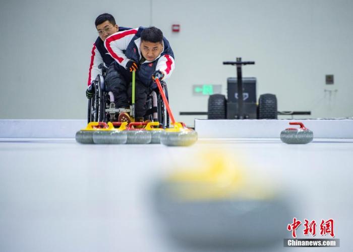 11月22日，中新社記者前往位于北京市順義區的中國殘疾人奧林匹克運動管理中心，探訪中國輪椅冰壺隊在此備戰北京2022年冬殘奧會的情況。北京2022年冬殘奧會將于2022年3月4日開幕。圖為中國隊隊員王海濤(前)與隊友訓練。 中新社記者 侯宇 攝
