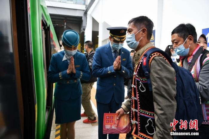 12月3日16时45分，载着700多名乘客的C3次动车“复兴号”缓缓驶出昆明火车站，标志着连接中国昆明和老挝首都万象、全线采用中国标准的中老铁路全线开通运营，老挝自此迈入铁路运输时代，也为构建中老命运共同体提供了有力支撑。图为列车员迎接首批旅客。 <a target='_blank' href='/'>中新社</a>记者 刘冉阳 摄