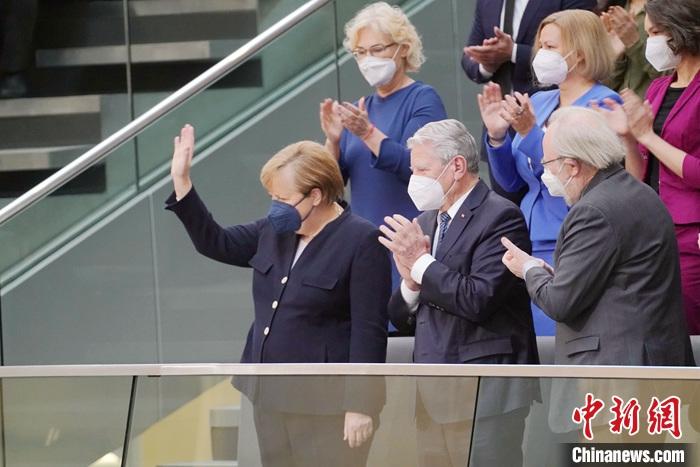 12月8日，德国联邦议院以395票的“总理当选所需多数票”选举朔尔茨为德国联邦总理。图为当天上午选举投票前，参加投票的联邦议院议员集体起立鼓掌，向即将卸任的默克尔致意。 <a target='_blank' href='/'>中新社</a>记者 彭大伟 摄
