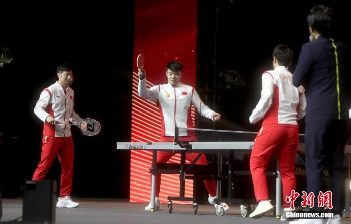 12月20日，內地奧運健兒代表團參加在澳門東亞運體育館舉辦的聯歡會。圖為馬龍(左)、王懿律(中)互換球拍，表演趣味乒乓球比賽。 <a target='_blank' href='/'>中新社</a>記者 張宇 攝