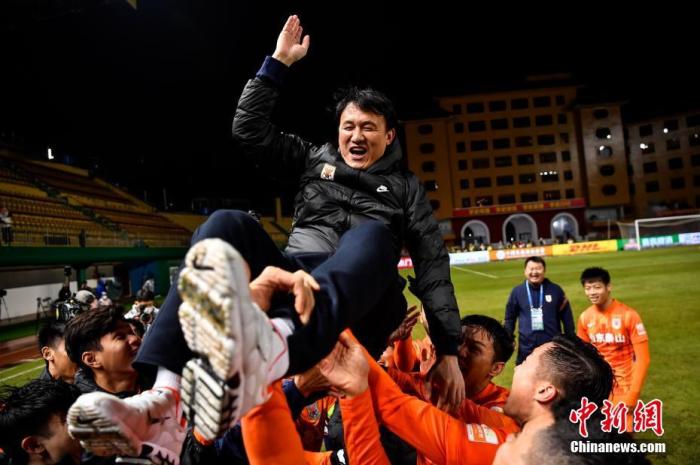 图为赛后山东泰山队队员抛起主教练郝伟庆祝。图片来源：ICphoto