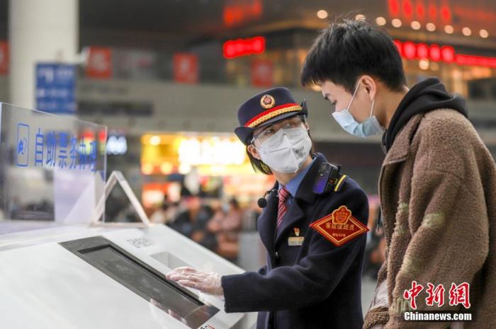 2022年1月3日，南昌车站客运工作人员正在协助旅客使用自助查询机查看车次信息。 <a target='_blank' href='/'>中新社</a>发 鲍赣生 摄 图片来源：CNSPHOTO