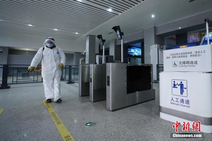 资料图：工作人员在西安火车站进站口处开展消杀作业。 <a target='_blank' href='/'>中新社</a>发 尤艇 摄