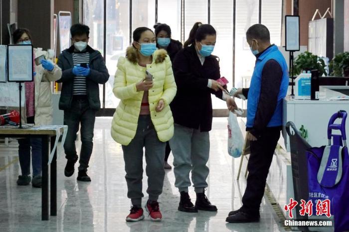 资料图：陕西西安未央区，工作人员对进入超市的市民进行测温。 中新社记者 张远 摄