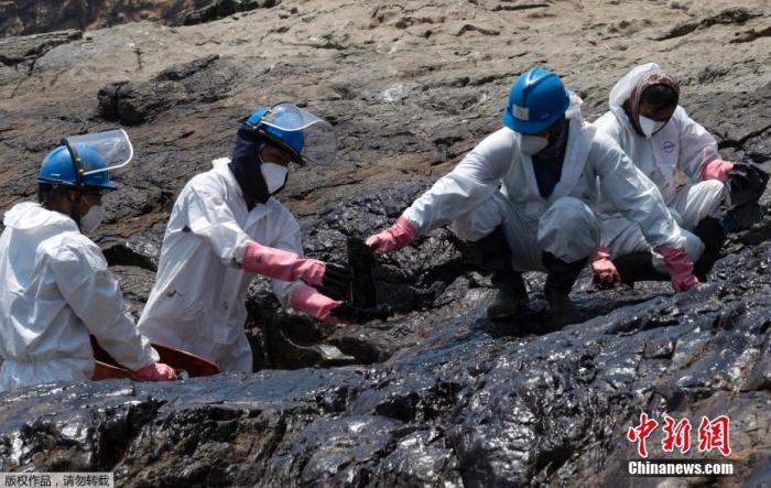 当地时间1月17日，受汤加火山喷发后的影响，秘鲁Callao海域出现异常海浪波动，一艘船舶在与炼油厂卸货过程中发生泄漏事故，海滩遭到污染。图为相关工作人员清理海滩上的油污。