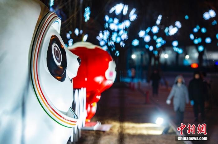 1月20日晚间，位于北京市海淀区五塔寺路的“冰雪廊道”景观亮灯，市民途经北京2022年冬奥会吉祥物“冰墩墩”造型和冬残奥会吉祥物“雪容融”造型。 中新社记者 侯宇 摄