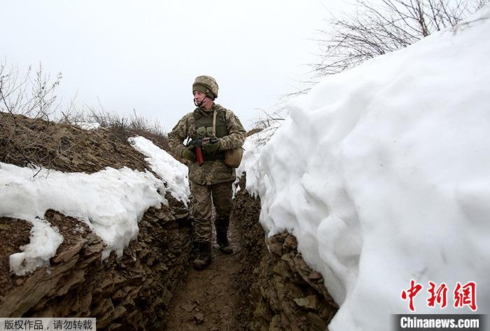 2022年1月11日，一名乌克兰士兵在顿涅茨克地区卢甘斯克村附近的战壕中巡逻。