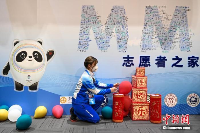 资料图：1月28日，北京冬奥会主媒体中心一位志愿者正在装扮“志愿者之家”。 中新社记者 何蓬磊 摄