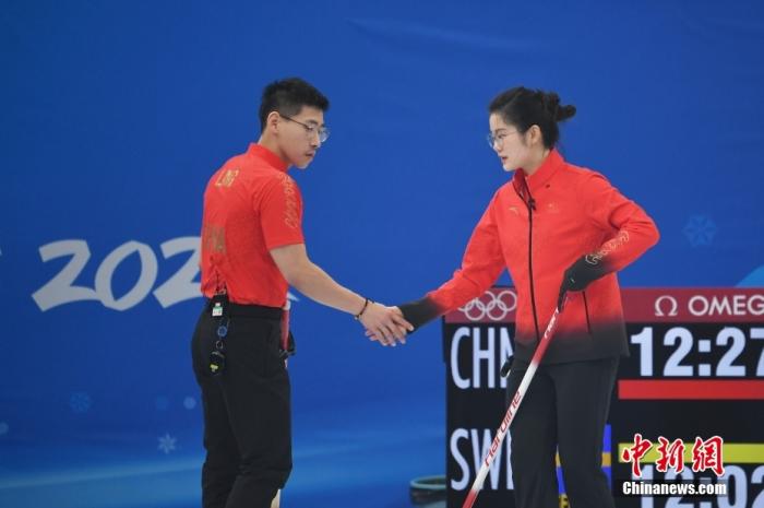 2月3日晚，北京2022年冬奥会冰壶项目混合双人循环赛在国家游泳中心继续进行，中国队在比赛最后时刻被瑞典队逆转，以6:7憾负。图为中国选手凌智(左)、范苏圆在投壶后击掌。 中新社记者 李骏 摄 　