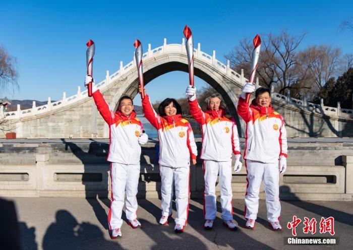 2月4日上午，北京2022年冬奥会火炬接力在颐和园举行。图为第31棒火炬手窦桂梅（左二）、第32棒火炬手范迪安（左三）与第34棒火炬手刘强、第35棒火炬手陈波在绣漪桥前展示“飞扬”火炬。 中新社记者 侯宇 摄