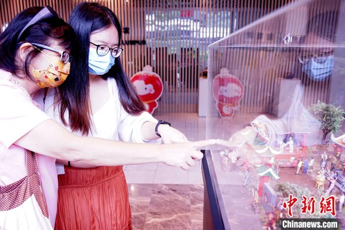 2月8日，马来西亚吉隆坡中国文化中心，前来参观“农历新年·全手工微雕艺术特展”的黄秀娟（左一）为女儿黄佩佩指点微雕呈现的自己的“过年回忆”。 <a target='_blank' href='/'>中新社</a>记者 陈悦 摄