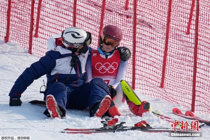 2月9日，美国选手米凯拉在障碍滑雪赛中第一轮就被淘汰，坐在场边一脸沮丧，她的队友赶来安慰。