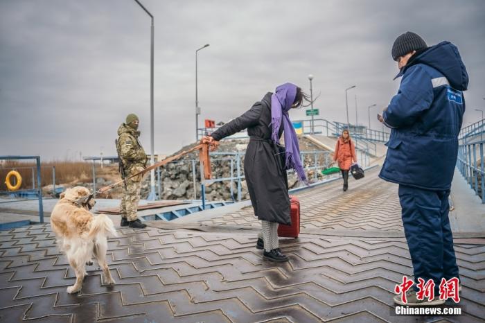 当地时间2月26日，乌克兰敖德萨地区，一名乌克兰妇女带着一只狗登上渡轮前往罗马尼亚。图片来源：视觉中国