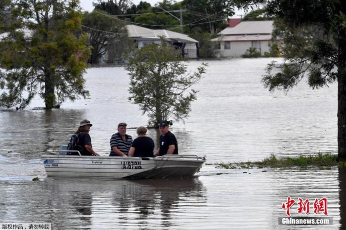 当地时间3月2日，澳大利亚新南威尔士州，人们坐船通过被洪水淹没的街道。