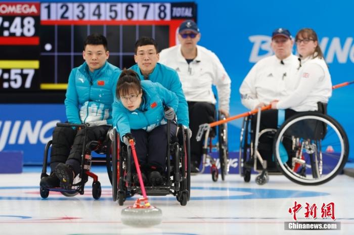 3月10日，北京2022年冬残奥会轮椅冰壶循环赛第十五轮比赛在国家游泳中心举行，中国队以6比3战胜英国队。图为中国队队员闫卓(蓝衣前排)掷壶。 <a target='_blank' href='/'>中新社</a>记者 韩海丹 摄