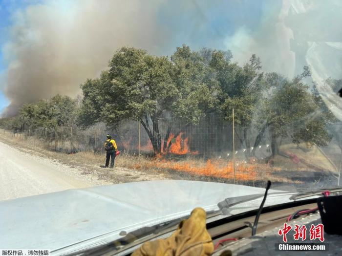 当地时间3月18日，美国得克萨斯州山火继续蔓延，消防员在火场灭火。