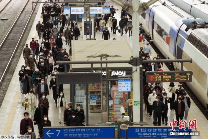当地时间3月17日，在韩国首尔的首尔火车站，人们戴着口罩预防新冠病毒。