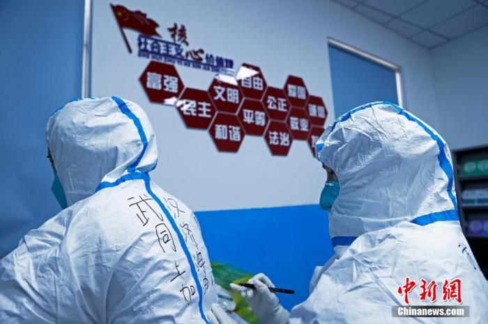 資料圖：華中科技大學同濟醫院醫護人員在隔離服上寫上“上海加油”字樣。 殷立勤 攝