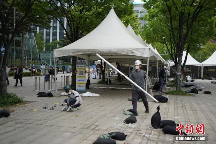 当地时间4月22日，韩国首尔市政府宣布位于首尔广场的临时核酸检测点终止运营，并于当日中午12时起开始拆除工作。据悉，该临时检测点开设于2021年7月9日，总面积为660平方米，共有19顶帐篷和8个集装箱，含签到区和样本区、仓库、休息厅等，累计进行检测258000人次。首尔广场临时核酸检测点拆除后，首尔市政府将在清溪广场临时运营“市政府直营检查所”。 中新社记者 刘旭 摄