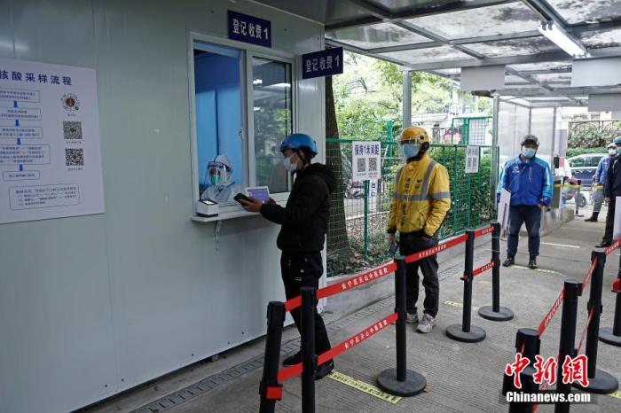 4月27日，快递员在上海市长宁区云雾山路39号的天山中医医院核酸采样点进行核酸检测。殷立勤 摄