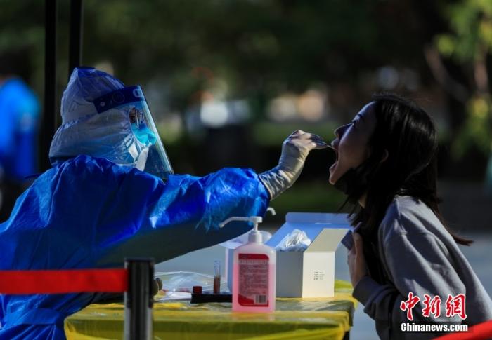 5月9日，北京市朝陽區一処核酸檢測點，毉務人員爲市民做咽拭子採樣。 中新社記者 賈天勇 攝