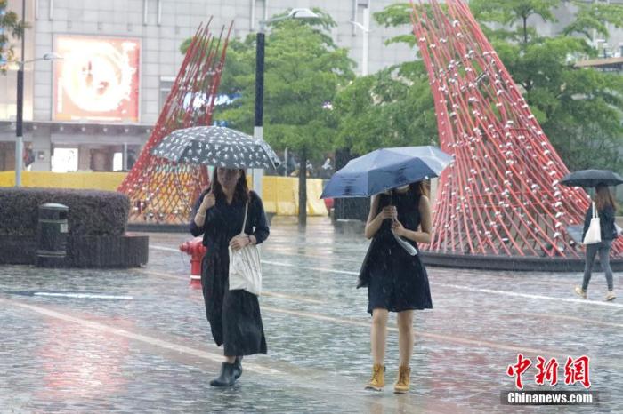 香港市民冒雨出行。 陈永诺 摄