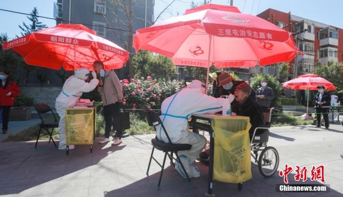资料图：5月15日，北京市朝阳区三里屯街道一处核酸检测点，医护人员为市民采样。中新社记者 贾天勇 摄
