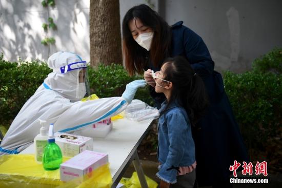 A nucleic acid testing volunteer takes a swap sample from a resident at a community in Shanghai, May 14, 2019.  (Photo: China News Service/Tian Yuhao)