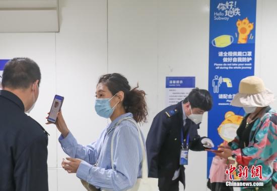 A passenger shows her health code at Hujialou Railway Station in Beijing, May 17, 2022. (Photo/China News Service)