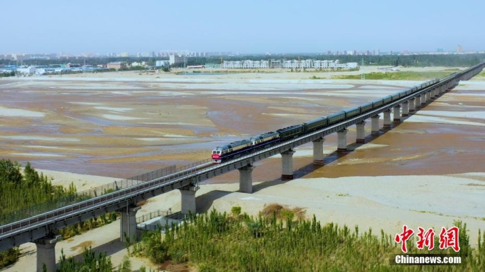 6月16日，和若铁路开通运营，首发列车穿过和田玉龙喀什河。 穆合塔尔 摄