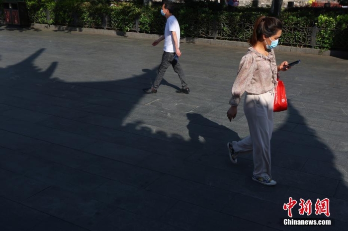 6月17日，江苏南京，市民在高温下的街头出行。当日，江苏南京、扬州、徐州、宿迁、淮安等地发布高温橙色预警。 <a target='_blank' href='/'>中新社</a>记者 泱波 摄