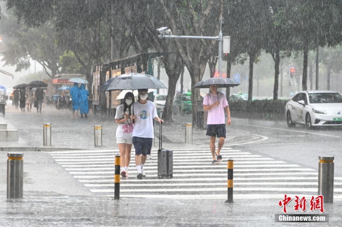 7月3日，廣東省廣州市，市民雨中出行。當日，受臺風“暹芭”外圍螺旋雨帶北抬影響，廣州市城區出現暴雨天氣。 中新社記者 陳驥旻 攝 