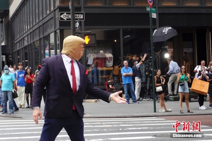 資料圖：當地時間8月10日，一名戴著面具的示威者在美國紐約特朗普大廈外模仿美國前總統特朗普。近兩日，特朗普大廈前示威者、記者、圍觀民眾等人流聚集。 <a target='_blank' href='/'>中新社</a>記者 廖攀 攝
