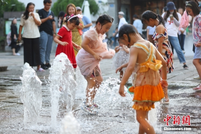 8月12日，江苏南京，小朋友在街头喷泉处戏水纳凉。当日，南京市气象台继续发布高温红色预警信号。 <a target='_blank' href='/'>中新社</a>记者 泱波 摄