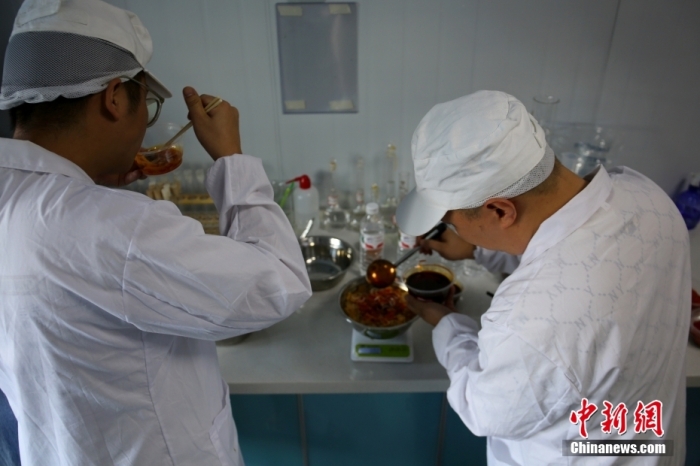 8月14日，在廣西柳州市一家螺螄粉生產企業內，兩名試辣師正在對一批新生產的袋裝螺螄粉中的辣油包進行口味測試。 <a target='_blank' href='/'>中新社</a>記者 蒙鳴明 攝
