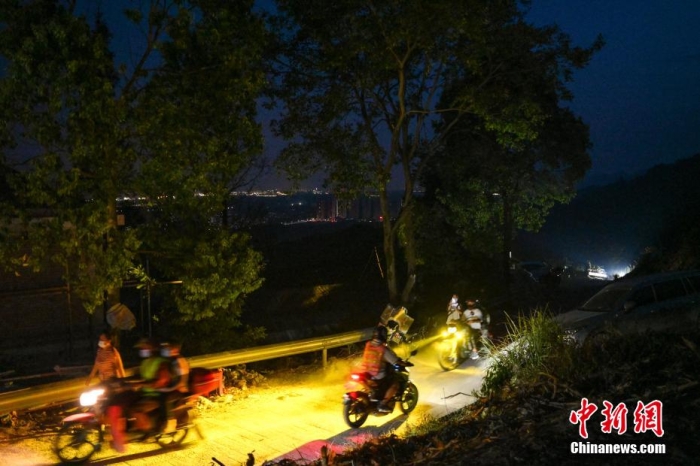 圖為8月25日晚，自發組成的摩托車隊正往返在崎嶇的山路上運送人員、物資。 何蓬磊 攝