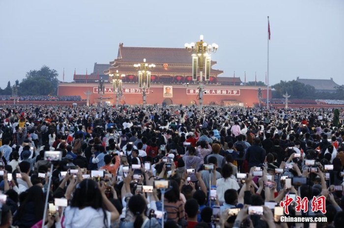 10月1日，北京天安门广场举行国庆升国旗仪式，来自四面八方的(de)市民游客齐聚广场，共同见证五星红旗冉冉升起的(de)庄严时刻，庆祝新中国73周年华诞。 中新社记者 盛佳鹏 摄 
