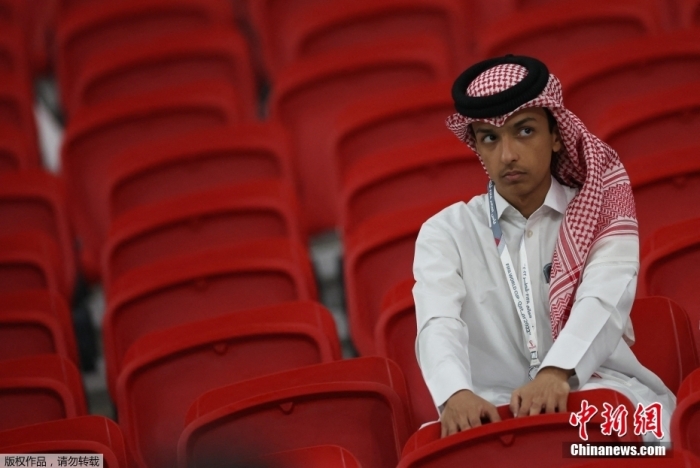 一名卡塔尔队的小球迷站在看台上，神情沮丧。