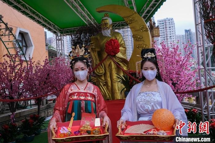 图为身穿汉服的女士展示黄大仙祠新春期间向善信派发的福物。  中新社记者 陈永诺 摄