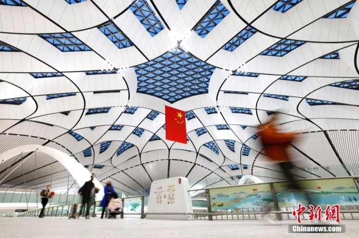 1月17日9时，中国南方航空CZ309航班从北京大兴国际机场启程飞往香港。这是近3年来，大兴机场首架国际及港澳台地区客运航班，标志着大兴机场国际及港澳台地区客运航线正式恢复。图为旅客前往登机口。 中新社记者 富田 摄 　