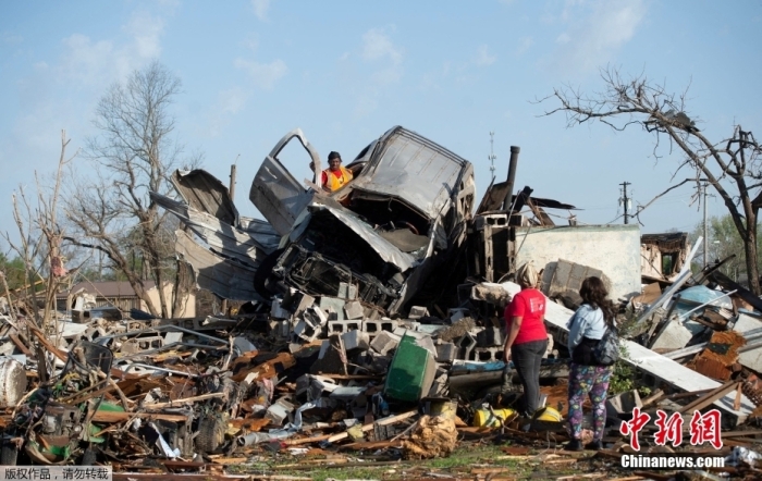 图为当地时间3月25日，密西西比州罗林福克镇，民众查看房屋车辆受损情况。
