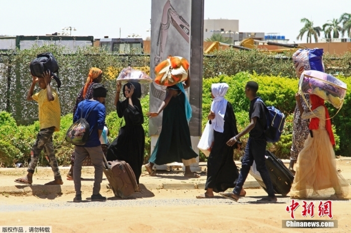 苏丹武装部队和快速支援部队之间的武装冲突仍在持续，首都喀土穆依然枪炮声不断，连日来的激烈交战已造成近2000人伤亡，欧盟驻苏丹大使也遭遇袭击。

据美联社报道，当地时间4月17日，喀土穆部分地区和邻近城市恩图曼遭频繁空袭，苏丹武装部队总部附近飘起白烟，枪声持续不断。在喀土穆人口密集区，坦克、机枪、火炮和战机轮番上阵，混乱场面前所未有，有居民报告家中停电及遭遇抢劫。

图为当地时间4月18日，民众携带行李从喀土穆南部逃离。