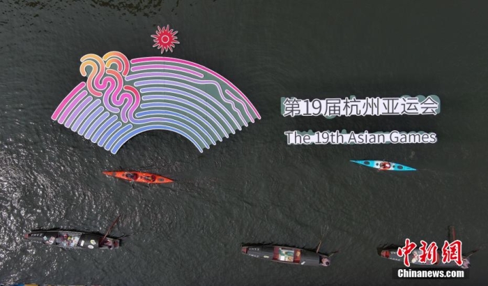 材料图为乌篷船和皮划艇从杭州亚运会标识前划过。时天王刚 摄