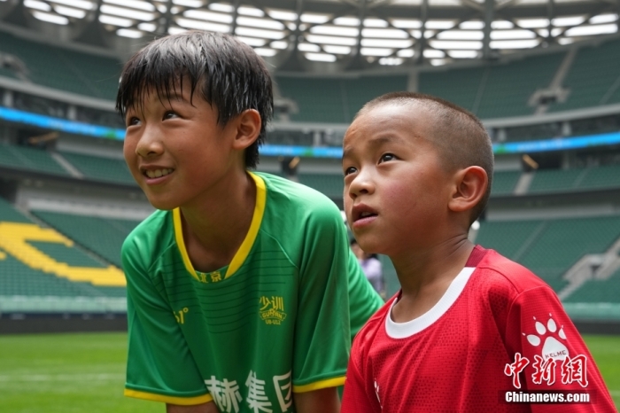 图为北京国安小球员陈小北和7岁的俄金仁增在一起观看场内播放的纪录片。中新社记者 崔楠 摄