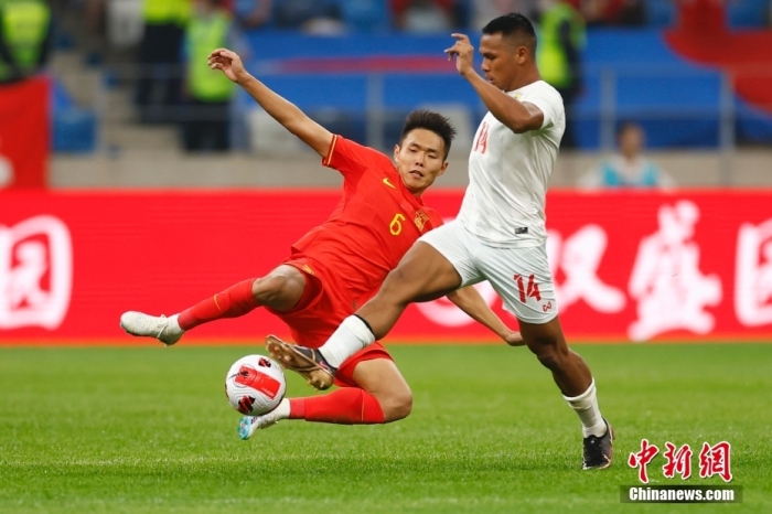 6月16日，中国队球员王上源（红衣）在比赛中戍守。中新社记者 富田 摄