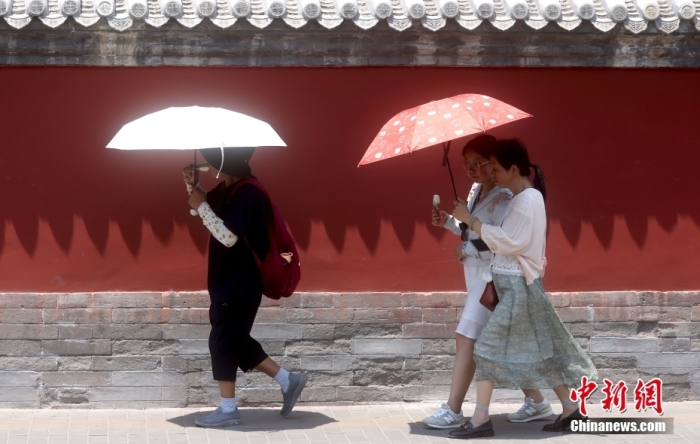 6月23日，北京鼓楼外，行人在烈日下出行。当日，北京市气象台升级发布高温红色预警信号。<a target='_blank' href='/'>中新社</a>记者 张宇 摄