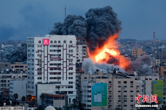 当地时间10月7日，在以色列军队袭击加沙城内一座高楼后，现场火光冲天浓烟滚滚。